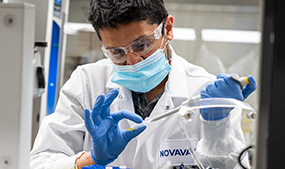man in lab coat holding vial